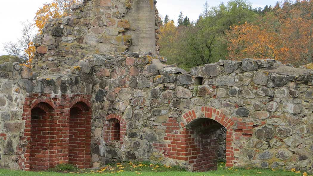 Ruins, autumn trees behind.