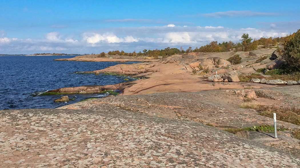 Long flat rocks sloping down into the sea.